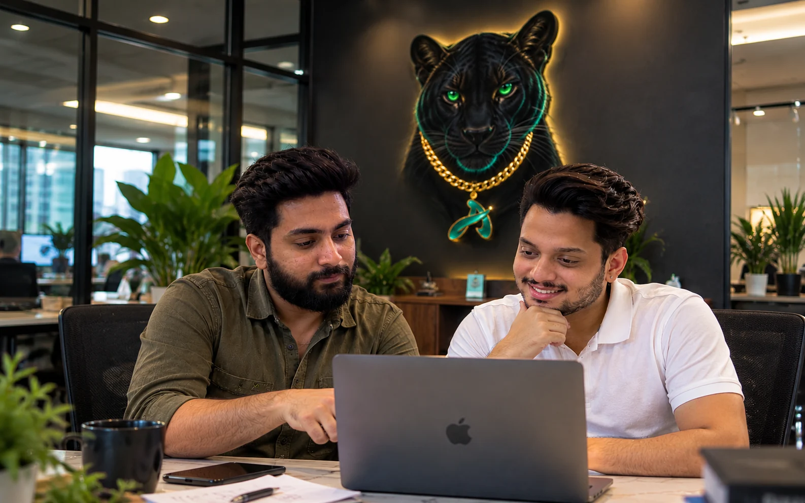 Two IDigitalAKKi Media strategists reviewing a campaign in front of the brand panther wall